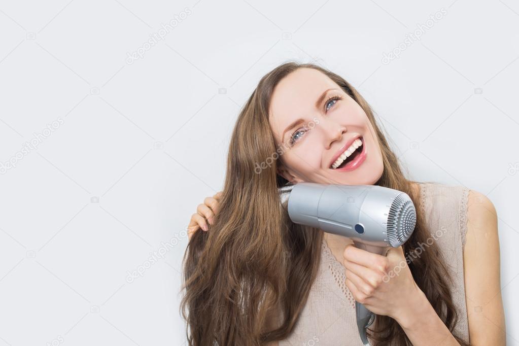 Happy woman blow drying hair