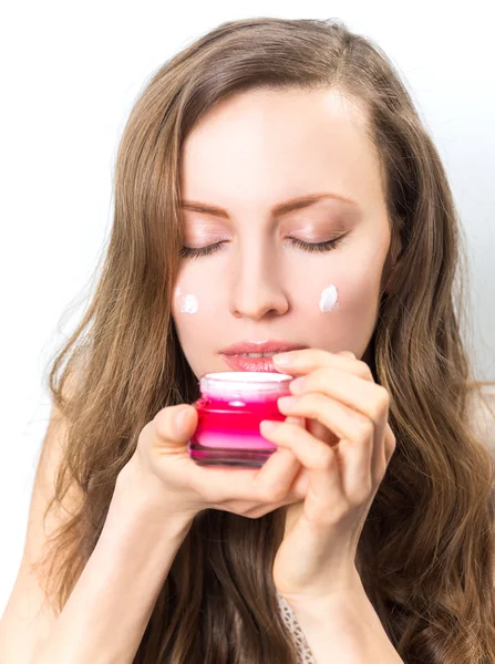 Mujer aplicando crema en su cara —  Fotos de Stock