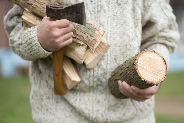 Handen van een man met de bijl en brandhout — Stockfoto