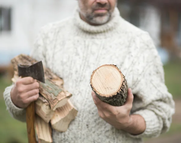 Manos de un hombre con hacha y leña — Foto de Stock