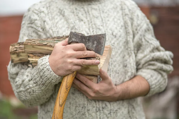 Hands of a man with axe and firewood — Stock Photo, Image