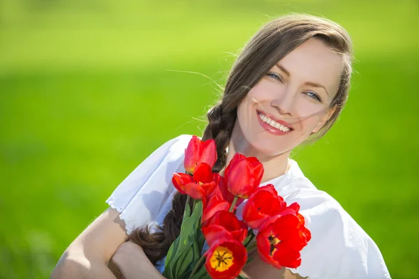 Mujer de belleza con tulipanes rojos — Foto de Stock