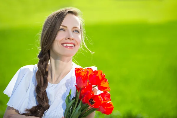 Krása ženy s červenými tulipány — Stock fotografie