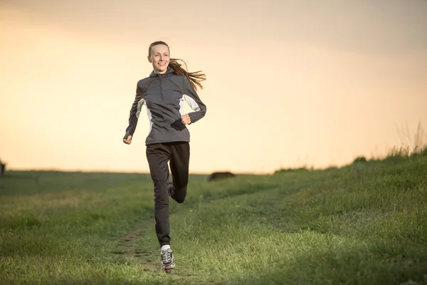 Running vrouw tijdens zonsondergang — Stockfoto