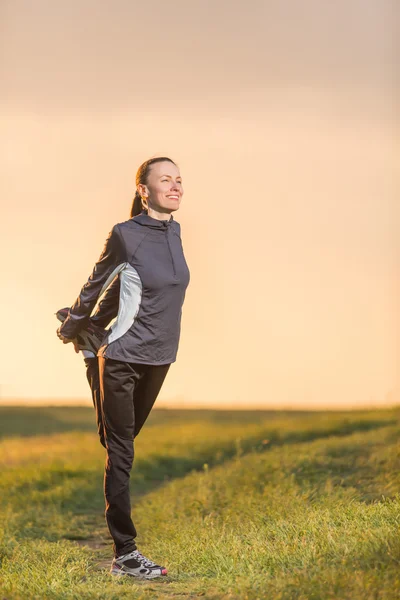 Fitness woman on sunset sky — Stock Photo, Image