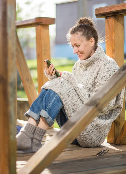 Mladá žena textilie s její telefon — Stock fotografie