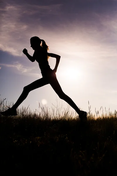 Running vrouw bij zonsondergang — Stockfoto