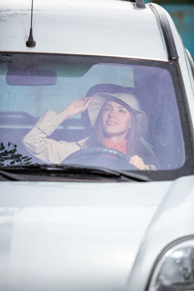 Kvinna i bil inomhus håller hjulet — Stockfoto