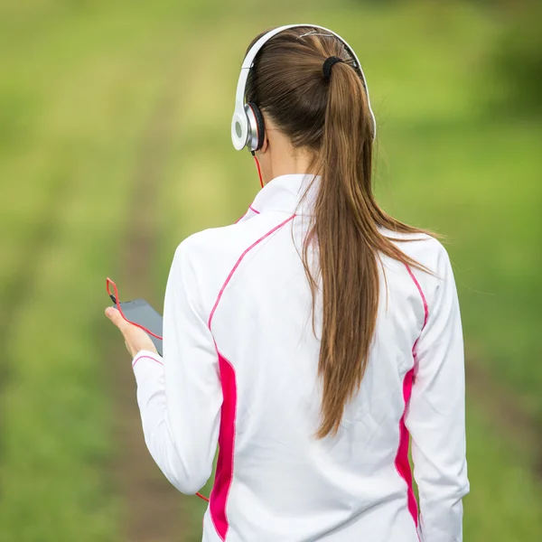 Бегущая женщина слушает музыку — стоковое фото
