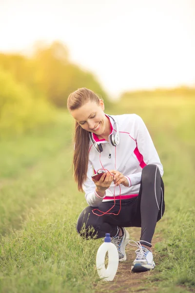 Schöne fitte Mädchen mit ihrem Handy — Stockfoto