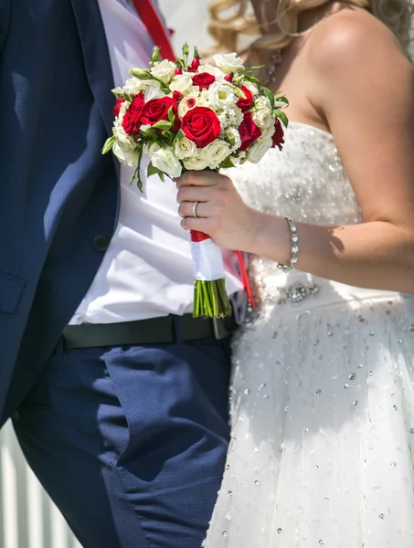 Pareja de boda con flores de color rojo brillante — Foto de Stock