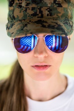 militare donna indossa cappello e occhiali da sole