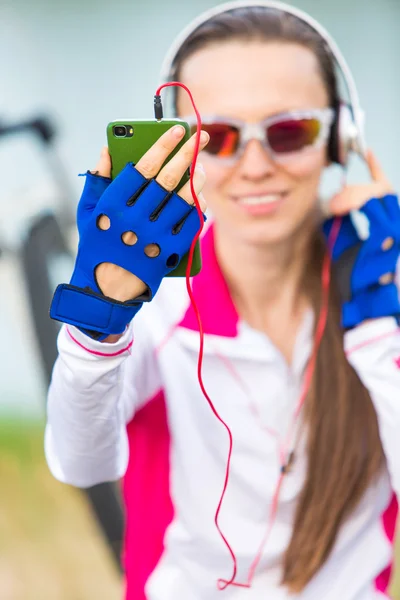 Счастливая женщина-велосипедистка с помощью мобильного телефона — стоковое фото