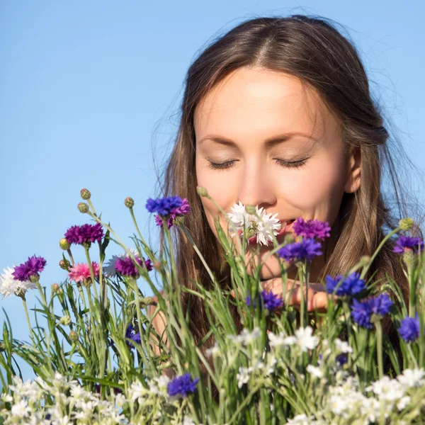 Mulher jovem bonita entre flores — Fotografia de Stock