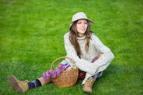 Jonge vrouw zittend op groen gras genieten van de natuur — Stockfoto