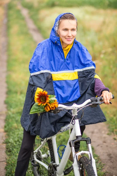 Menina de bicicleta no outono dia chuvoso — Fotografia de Stock
