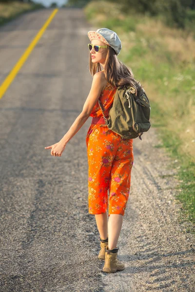 Beautiful young woman traveling alon a road — Stock Photo, Image