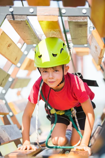 Jongen klimmen in avonturenpark — Stockfoto