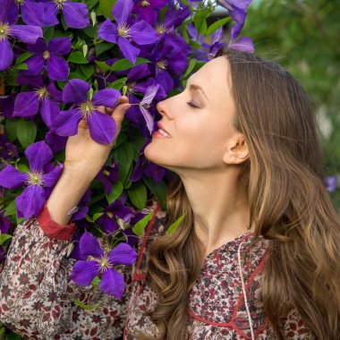 Young woman smelling flowers clipart