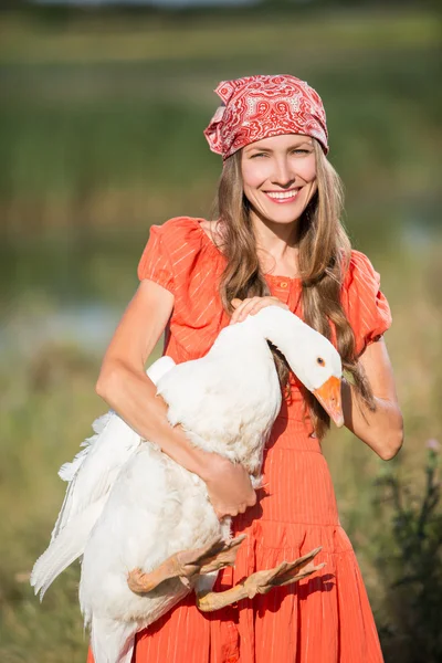 Bäuerin hält Gänse glücklich lächelnd — Stockfoto