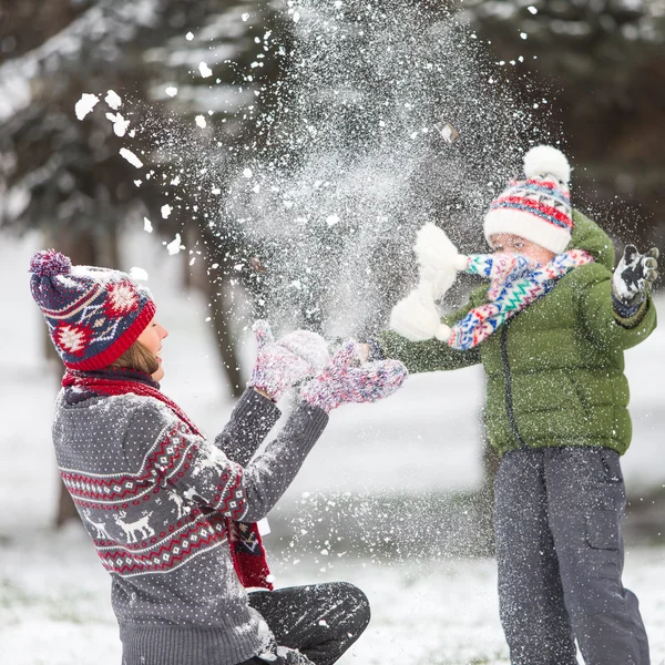 Happy mother and son in winter park having fun. focus on mother — Stock Photo, Image