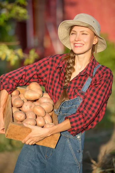 Mulher agricultor carregando legumes — Fotografia de Stock