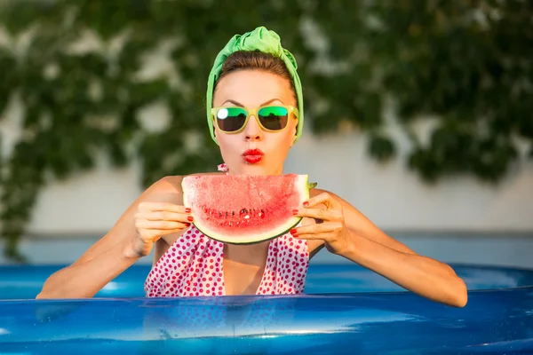 Skönhet modell med vattenmelon i poolen — Stockfoto