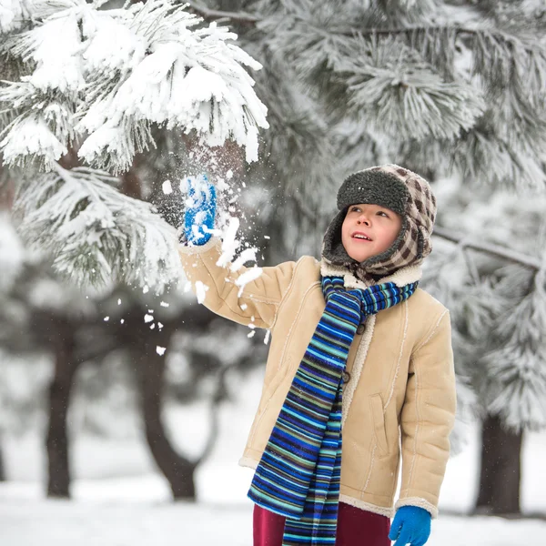 Zima - ładny chłopiec zabawy ze śniegiem w winter park — Zdjęcie stockowe