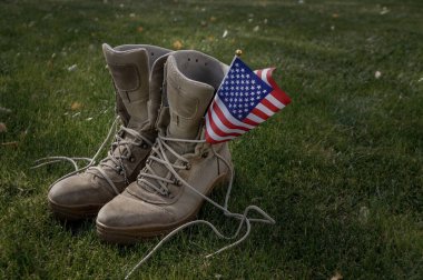 Rüzgarda sallanan bir Amerikan bayrağının sembolü olarak evine dönen bir Amerikan askerinin çizmeleri.