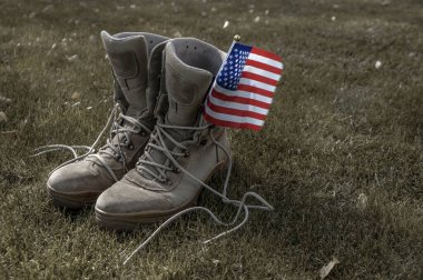 Rüzgarda sallanan bir Amerikan bayrağının sembolü olarak evine dönen bir Amerikan askerinin çizmeleri.