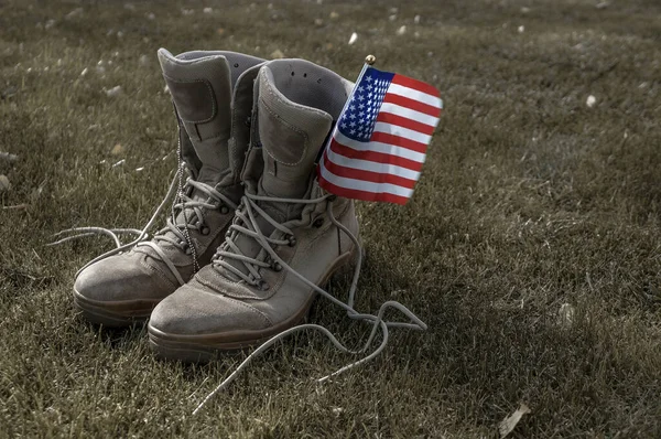 一个美国士兵的靴子 他作为英雄的象征回到家 带着一面美国国旗在风中飘扬 — 图库照片