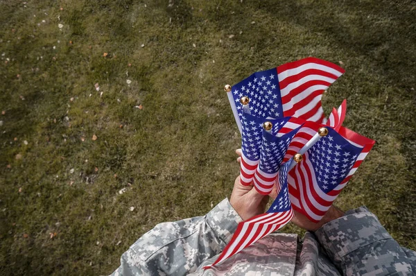 Americký Voják Drží Oběma Rukama Vlajky Vlající Větru Nad Zelenou Stock Obrázky