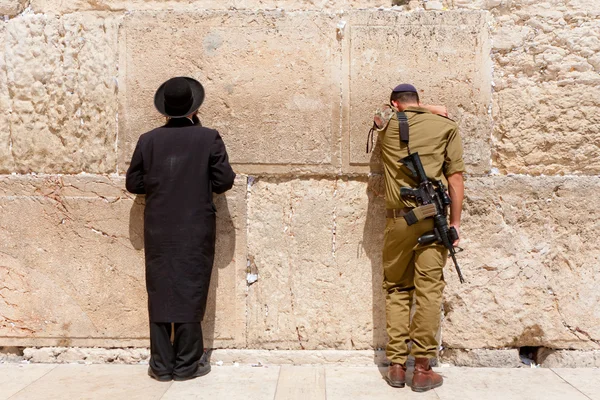 Soldaat en orthodoxe joodse man bidden op de westelijke muur, Jeruzalem — Stockfoto