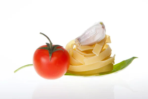 Arrangement of Tagliatelle pasta cherry tomato garlic and basil — Stock Photo, Image