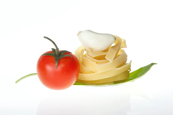 Arrangement of Tagliatelle pasta cherry tomato garlic and basil — Stock Photo, Image