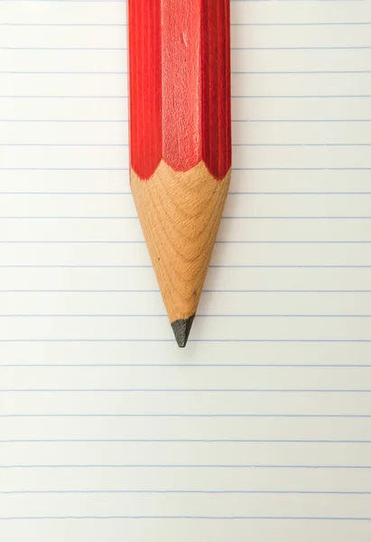Červenou tužku a linkovaný papír — Stock fotografie