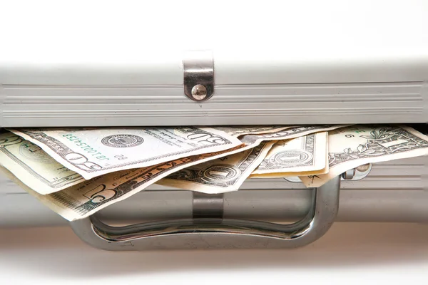 Серебряный чемодан с долларовыми банкнотами — стоковое фото