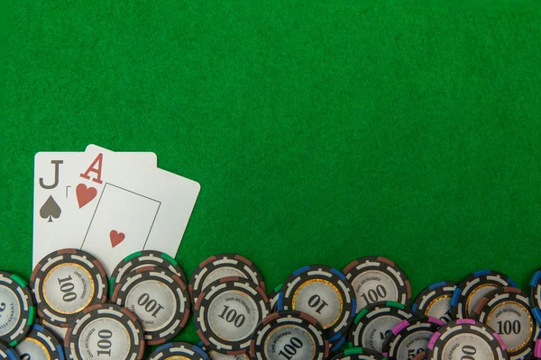 Jack y as tarjetas de blackjack con fichas sobre fondo verde —  Fotos de Stock
