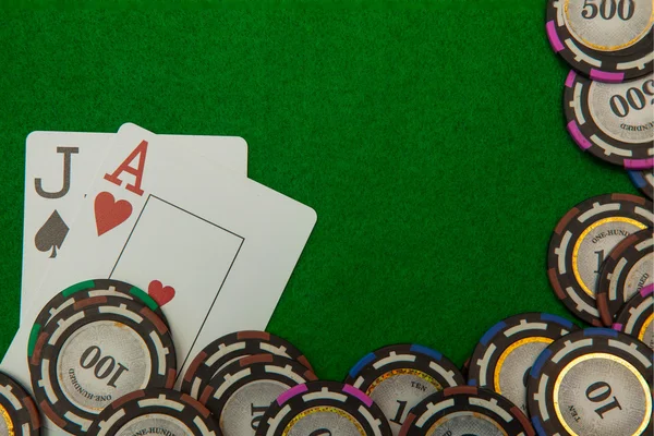 Jack y as tarjetas de blackjack con fichas sobre fondo verde —  Fotos de Stock