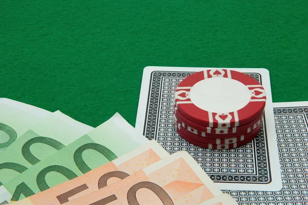 Two cards hand with Euro notes and chips on green background — Stock Photo, Image