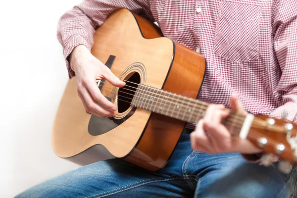 Shot of man in shirt and jeans playing on classic guitar — Stock Photo, Image