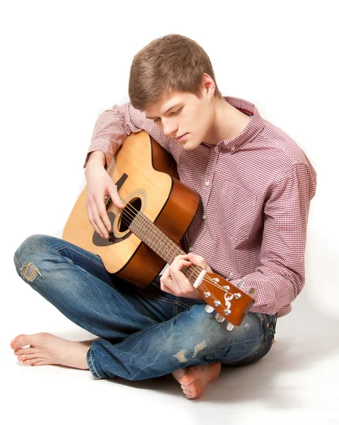 Man sitting on floor and playing on classic guitar — Stock Photo, Image