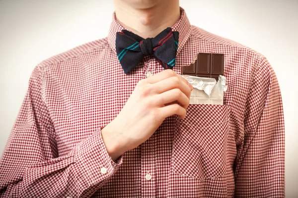 Uomo in camicia e papillon prendere il cioccolato dal taschino Immagine Stock