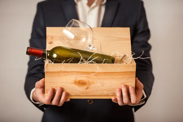 Uomo in giacca contenente scatola aperta con bottiglia di vino Fotografia Stock