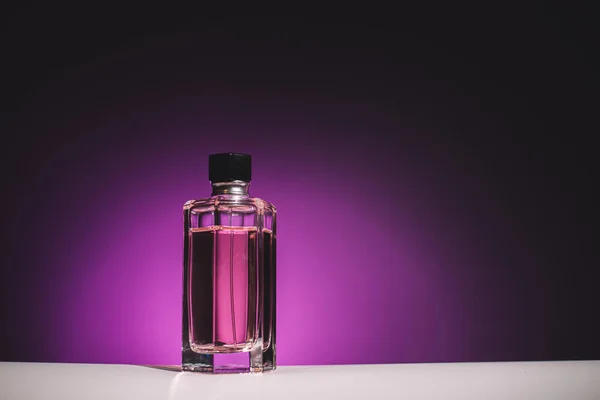 Bottle for woman perfume on lilac background