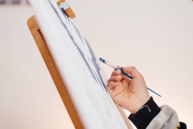 Fırçayla bir çocuk eli rakamlarla bir resim çizer