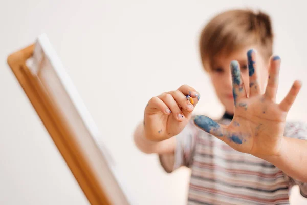 The boy draws a picture by the numbers.