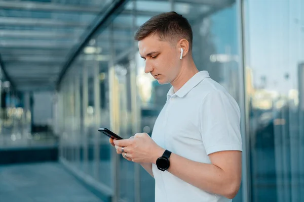 Young businessman man headphones and with a phone in his hands