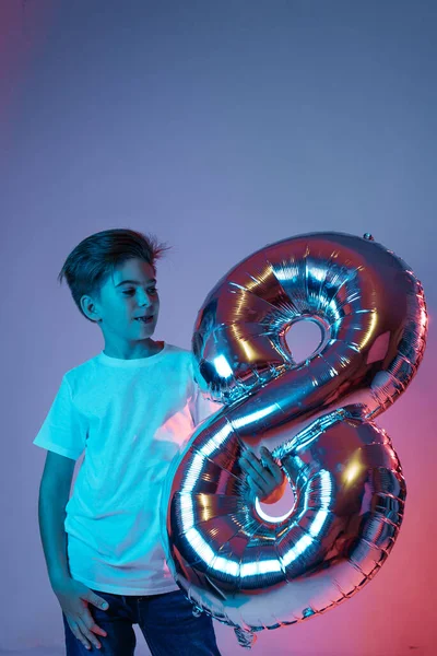 Boy with a balloon in the form of the number eight.