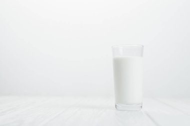 Beyaz arka planda bir bardak süt. Sütün faydaları.